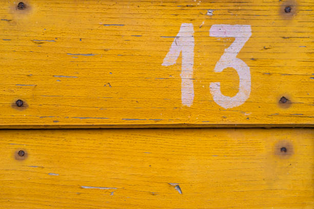 istock The number thirteen painted on a board with old nails. 2191381511