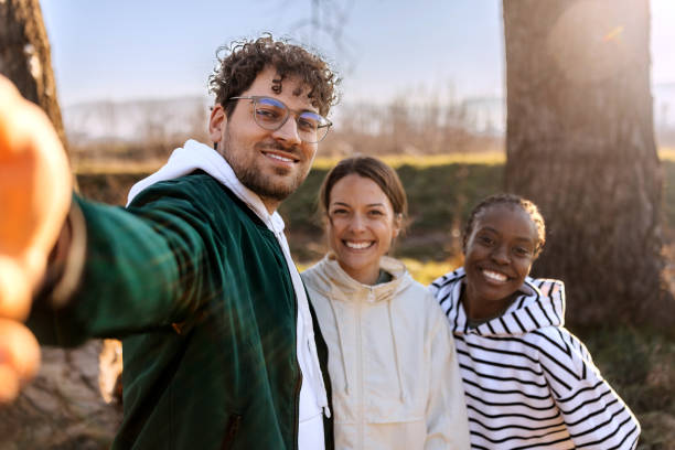 istock Smiling friends taking selfie while enjoying sunny day outdoors 2191382384