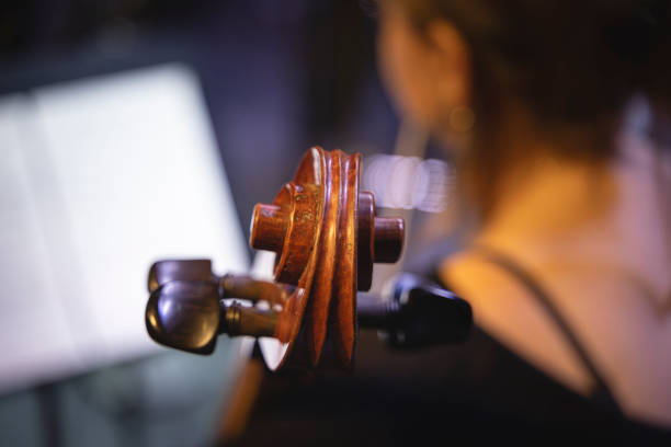color photo with a close-up of a female cello player during a concert in a concert hall