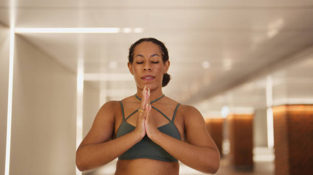 istock Woman Practicing Yoga with Hands in Namaste Pose 2191386606