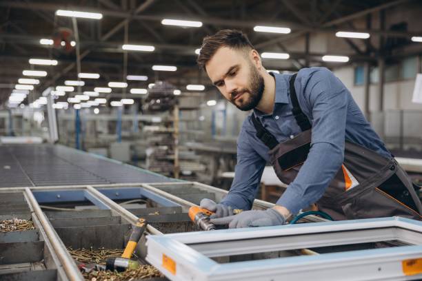 istock Factory worker assembling aluminum and PVC window frame on production line 2191387102