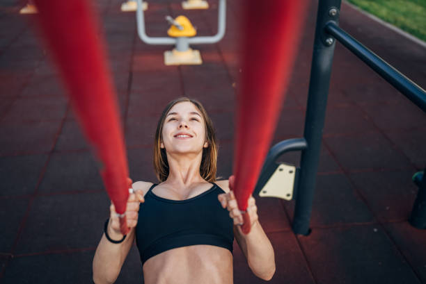 istock Woman using suspension straps in a park workout 2191388418