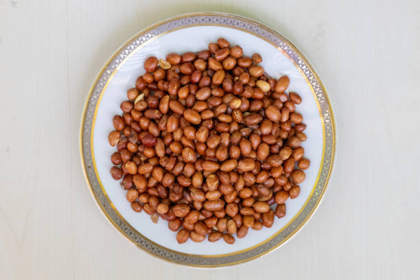 Roasted peanuts at an Asian night market street food stall under warm lights.
