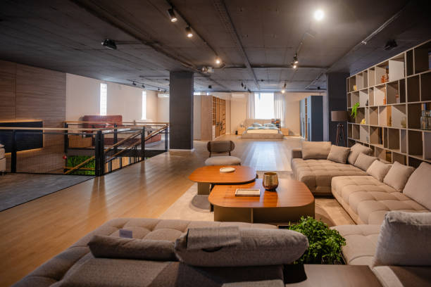 This image captures a modern lounge with ample natural light, featuring a sleek sectional sofa, coffee table setup, and stylish shelving in a cozy ambience.