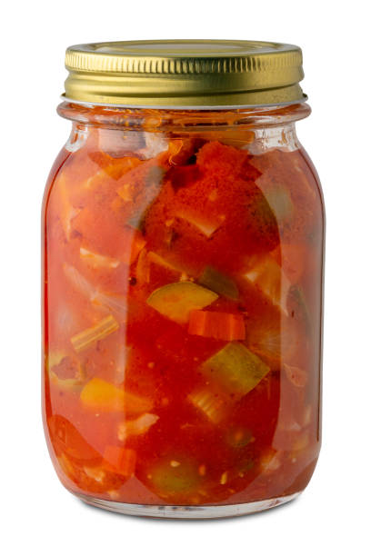 Mixed vegetables cooked in tomato sauce in glass jar isolated on white with clipping path included. Italian Giardiniera canned in glass jar