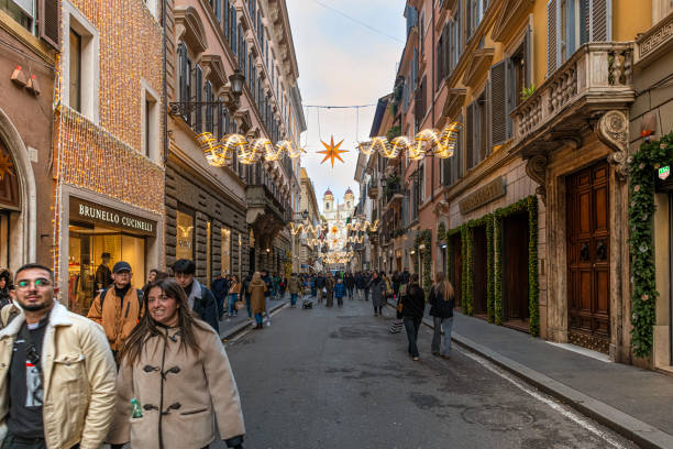 Rome, Italy-December 23, 2024: Via dei Condotti, Christmas decoration along the street and people walking down the street for shopping. On the background, Trinità dei Monti square and the Spanish steps.