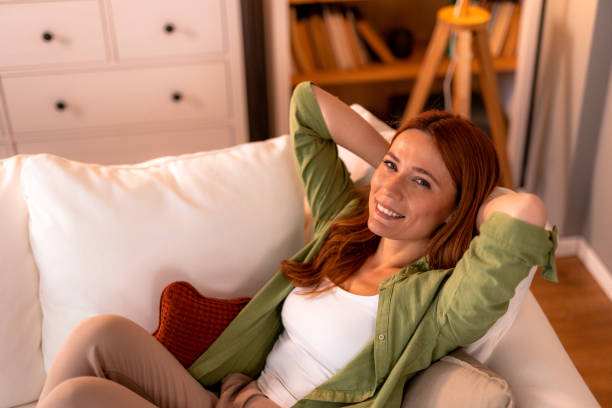 istock Serene woman relaxing on comfortable sofa at home, enjoying peaceful moment 2191395564