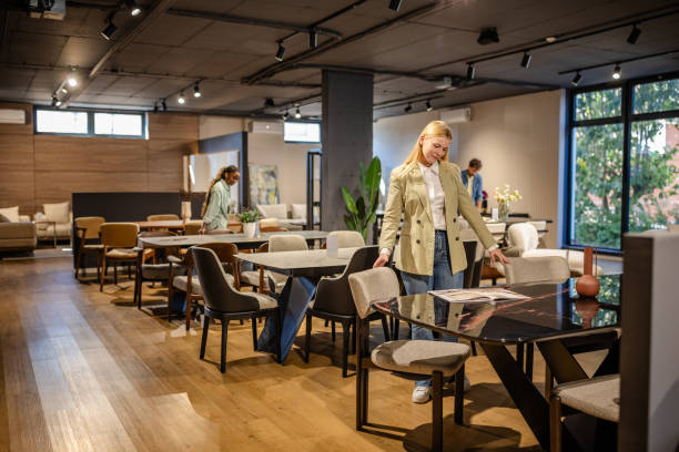 istock Woman examining a table in a beautifully lit showroom. 2191395576