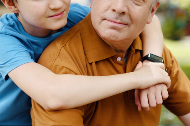 Close-up of grandson embracing his grandfather while they spending time together