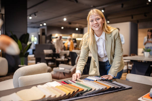 istock Happy woman evaluating fabrics in stylish showroom. 2191396014