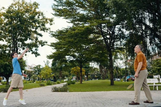 Grandfather playing badminton with his grandchild in the park