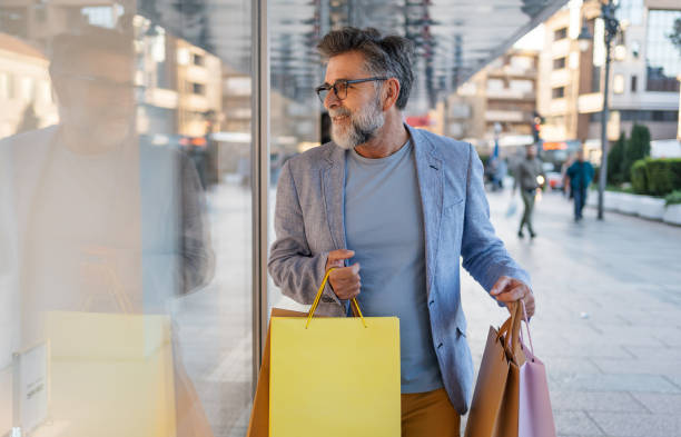 istock Mature man looking at a store window and enjoying shopping 2191400743