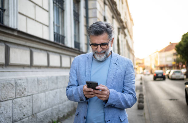 istock Mature man using smartphone outdoors 2191400940