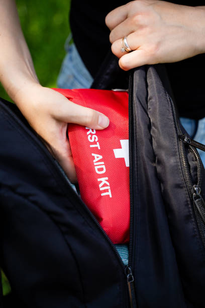 istock A person is carefully placing a first aid kit into their backpack, ensuring that it fits snugly and securely inside, as they prepare for their next adventure or activity 2191401036