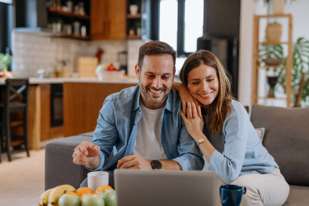 istock Happy couple relaxing on the sofa using a laptop at home 2191402291
