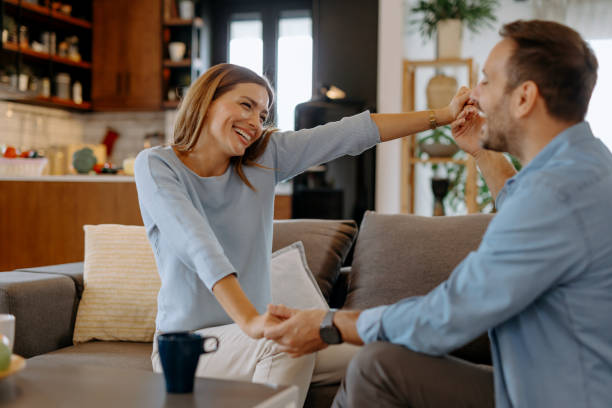istock Happy couple holding hands and having fun at home 2191402373