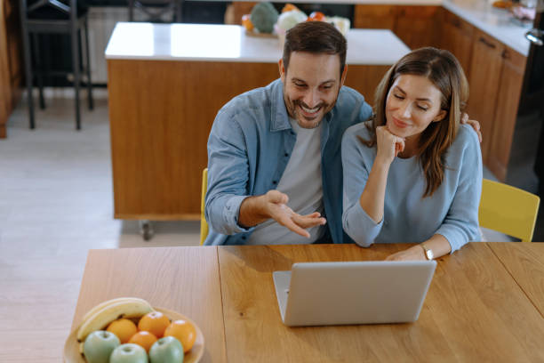 istock Happy couple having a video call in the kitchen using a laptop 2191402387