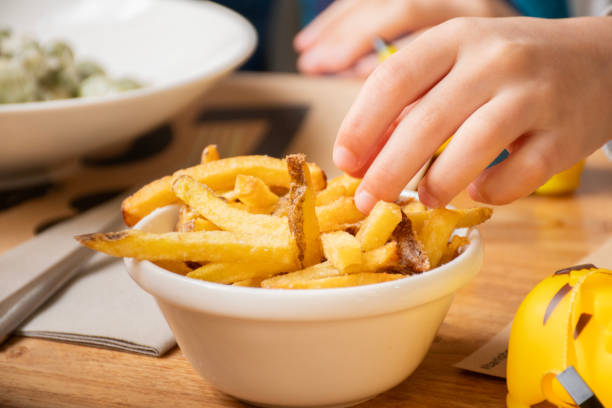 istock child hand eating fried potato chips unhealthy junk food avoid 2191402432