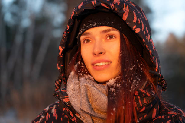 Beautiful young woman in winter forest. Close-up sunset portrait.