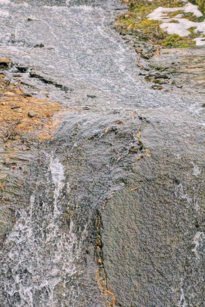 istock small waterfall stream of water flowing down grey stone wall 2191405017
