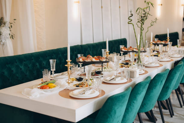 istock Elegant white wedding table setting with green velvet chairs and golden candlesticks 2191407570