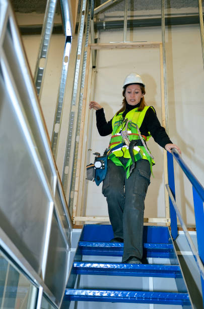 istock Construction worker descending metal stairs on building site 2191407641