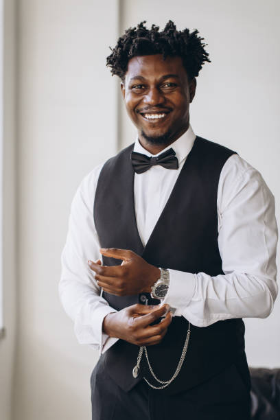 istock Elegant groom adjusting sleeves and smiling before wedding ceremony 2191407800