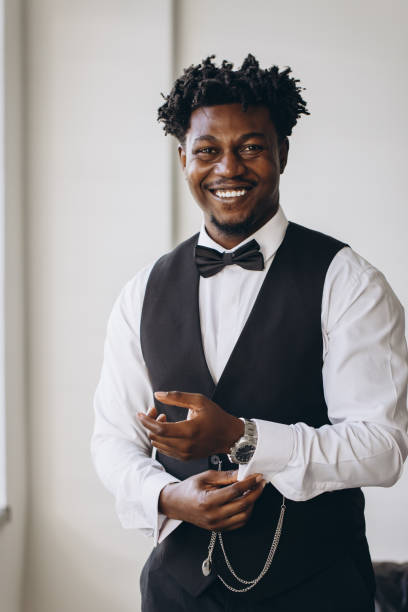 istock Elegant groom adjusting sleeves and smiling before wedding ceremony 2191407803
