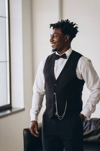 istock Elegant groom getting ready smiling and looking out the window 2191407814