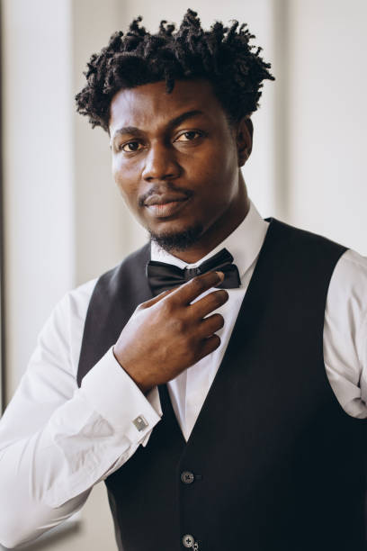istock Elegant groom adjusting his bow tie before wedding ceremony 2191407819