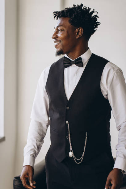 istock Elegant groom wearing suit and bow tie is getting ready for wedding ceremony 2191407820