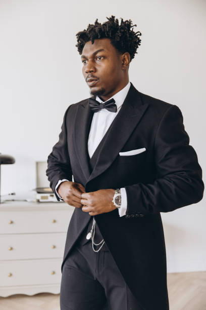 istock Elegant groom getting ready, buttoning his black suit jacket 2191407985