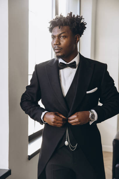istock Elegant groom getting ready, buttoning his black suit jacket 2191408033