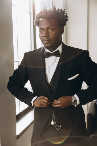 istock Elegant groom buttoning his black suit jacket 2191408055