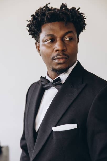 istock Elegant businessman wearing black suit and bow tie is posing 2191408062