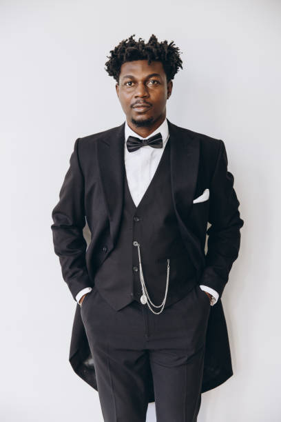 istock Elegant groom wearing black suit posing with hands in pockets 2191408105
