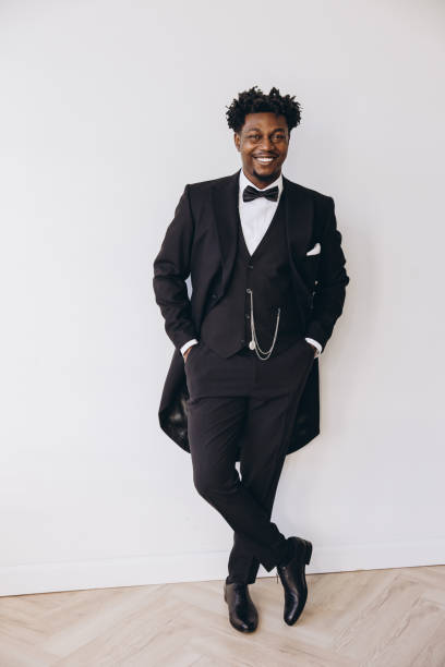 istock Elegant groom wearing black suit and bow tie posing before wedding 2191408108