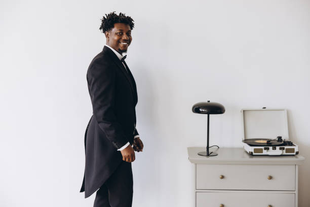 Elegant groom getting ready listening to vinyl records on turntable