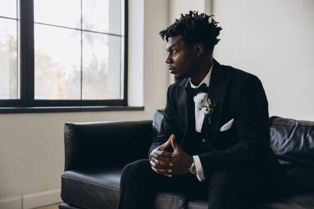 istock Groom wearing elegant suit sitting on sofa and waiting for bride 2191408468