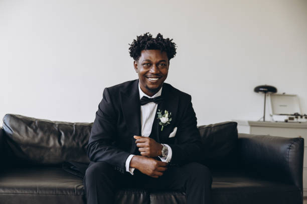 istock Elegant groom smiling and sitting on a couch before wedding 2191408483