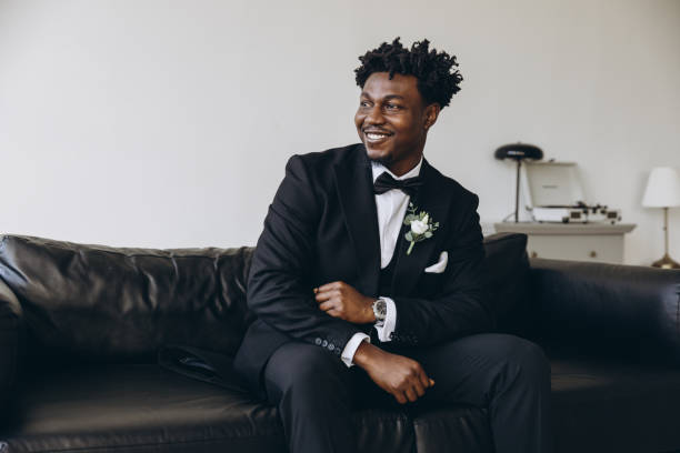 istock Smiling groom wearing elegant suit sitting on leather sofa 2191408495