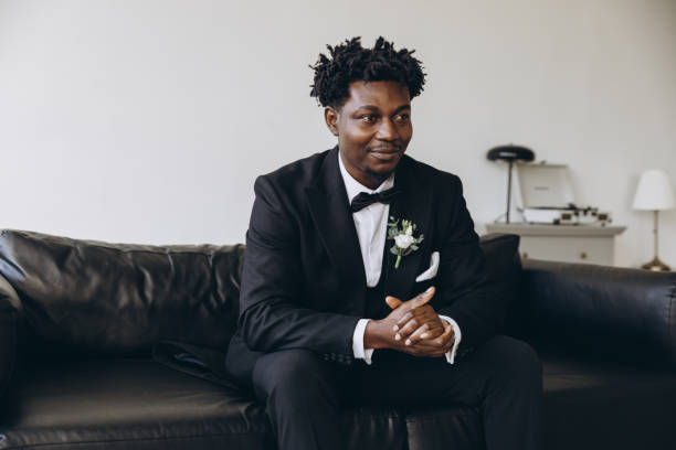 istock Groom wearing elegant suit sitting on leather couch waiting for bride 2191408497