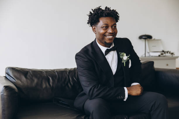 istock Groom smiling sitting on a couch waiting for the bride 2191408503