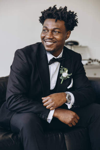 istock Smiling groom wearing elegant suit sitting on sofa 2191408516