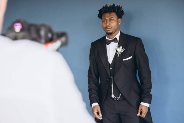 Videographer Filming Groom Wearing Tuxedo During Wedding Preparation