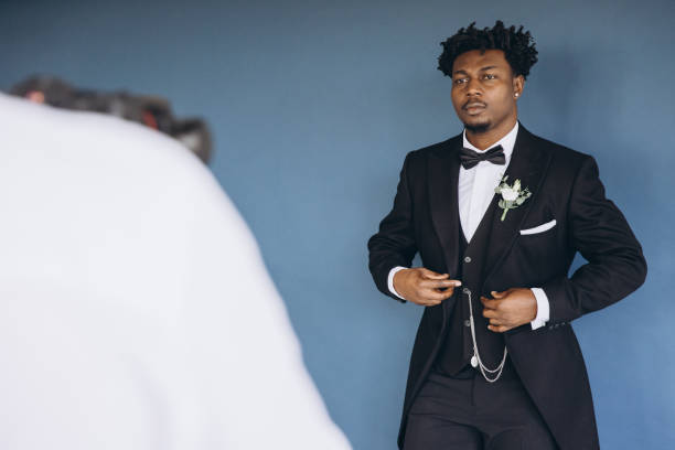 istock Groom wearing elegant suit adjusting his jacket while posing for photographer 2191408625