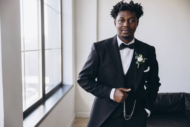 istock Elegant groom wearing suit posing in bright room 2191408707