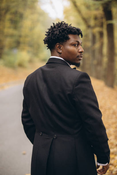 istock Groom wearing elegant suit walking in autumn park before interracial wedding 2191408747