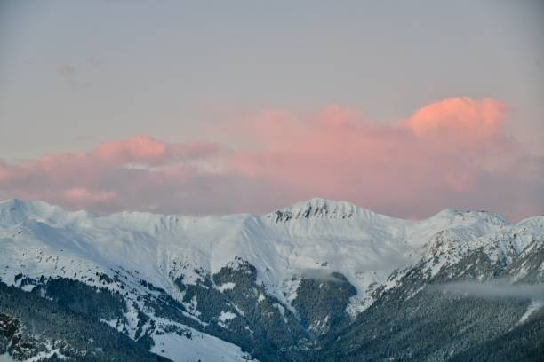 istock Snowcapped mountains under pink sky by sunset 2191408803