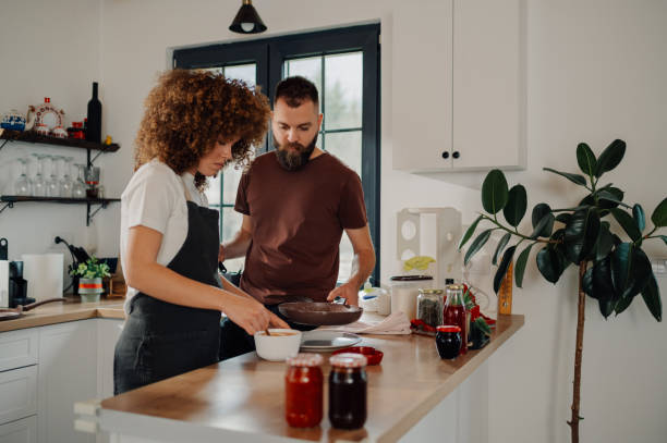 istock Couple cooking together in modern kitchen, preparing ingredients for meal 2191409460